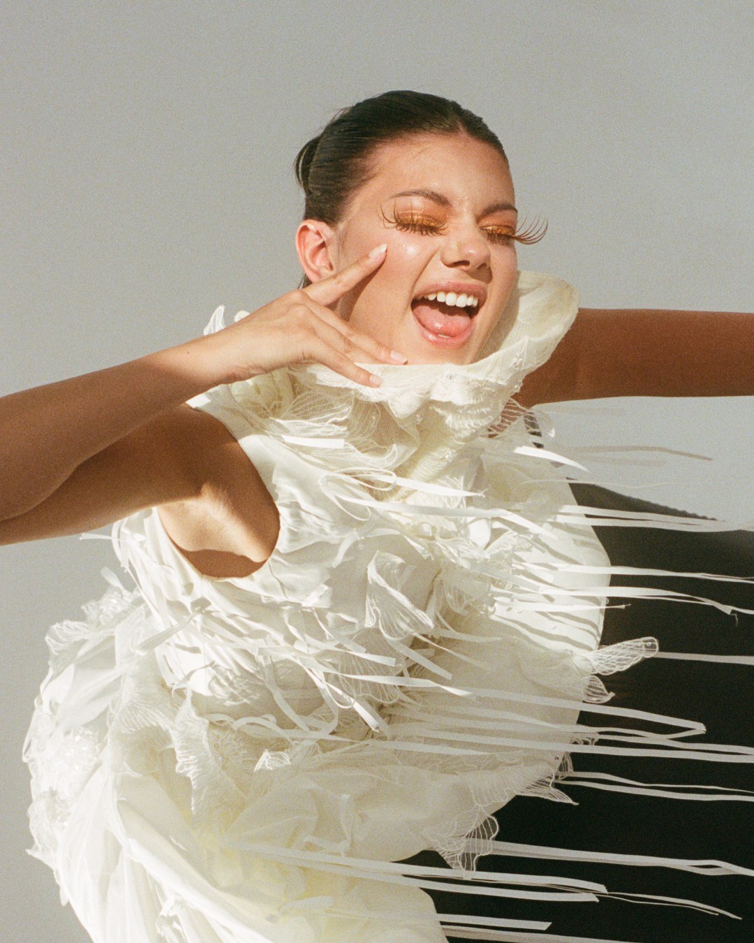 Model laughing in a textured fringed dress